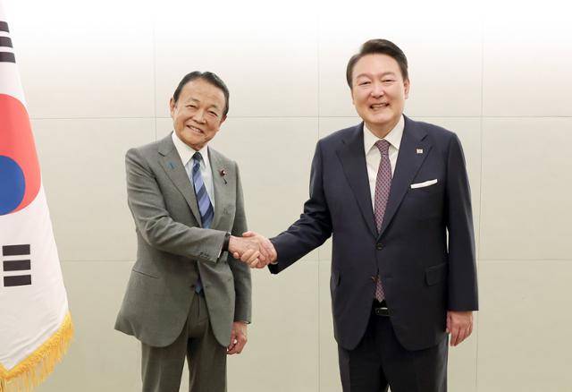 윤석열(오른쪽) 대통령이 17일 도쿄 시내 한 호텔에서 열린 일한협력위원회 접견에서 일본 자민당 부총재인 아소 다로 전 총리와 악수하고 있다. 도쿄=뉴시스