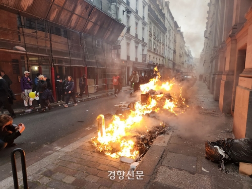 23일(현지시간) 경찰이 연금개혁 반대 시위대를 향해 최루탄을 쏜 파리 오페라광장 인근 골목에서 시위대가 붙인 불에 쓰레기가 타고 있다./박은하 기자
