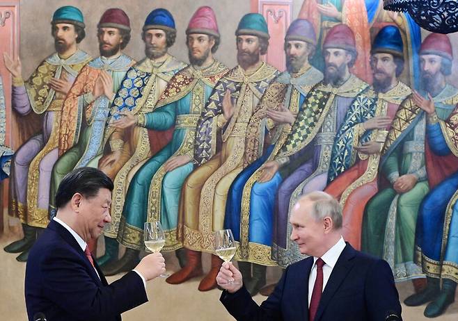 지난 21일 시진핑 중국 국가주석(왼쪽)과 블라디미르 푸틴 러시아 대통령이 모스크바 크렘린에서 정상회담을 한 뒤 열린 만찬에서 술잔을 들고 있다. 모스크바/로이터 연합뉴스