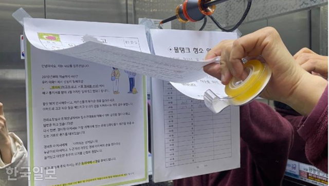 대구 달서구 한 아파트 입주민들이 엘리베이터에 붙여둔 '경비원 해고 취소 동의' 호소문 위에 관리사무소 측 '물탱크 청소' 등을 덧대 붙여둔 모습. 온라인 커뮤니티 캡처