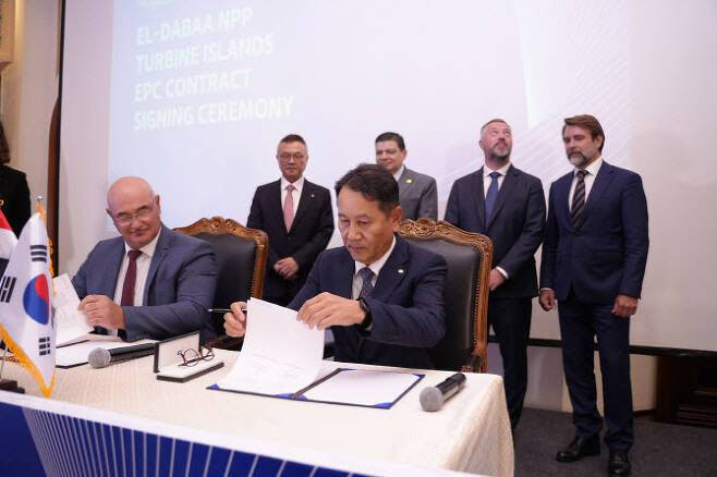 임정묵 한국수력원자력 이집트 카이로지사장(오른쪽)과 러시아 러시아 로사톰의 자회사 아톰스트로이엑스포트 JSC(ASE JSC)의 아나톨리 코브터너브(Anatoly Kovtunov) 카이로 지사장이 지난해 8월25일 이집트 엘다바 원자력발전소 2차측 건설사업 계약서에 서명하고 있다. 황주호 한수원 신임 사장(뒤 왼쪽) 등 관계자가 서명식에 배석했다.