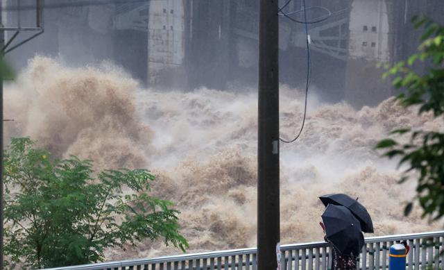 서울을 비롯한 중부지방에 이틀째 집중호우가 계속된 지난해 8월 9일 오전 시민들이 경기 하남 팔당댐에서 방류되는 물을 바라보고 있다. 연합뉴스