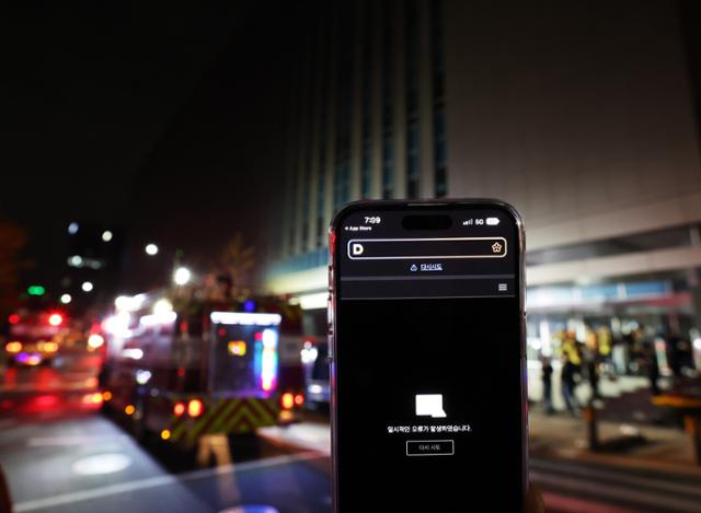 2022년 10월 15일 오후 화재가 발생한 경기 성남시 분당구 삼평동 SK 판교 캠퍼스 A동 앞에서 스마트폰 내 다음 애플리케이션에 오류 메시지가 표시되고 있다. 연합뉴스