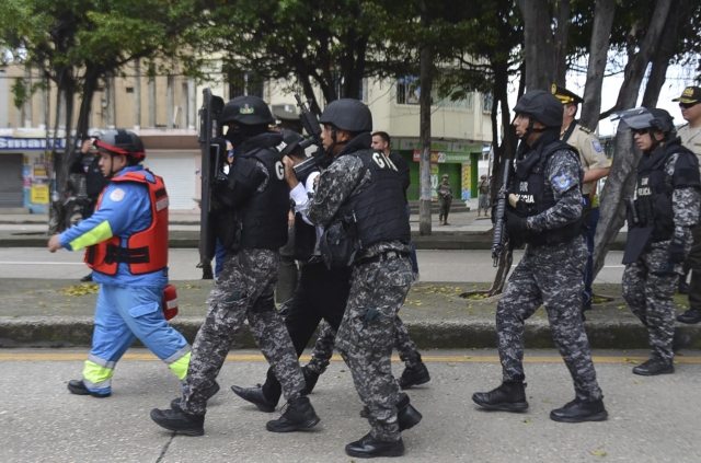 에콰도르 경찰이 30일(현지시간) 자국 최대 도시인 과야킬에서 몸에 폭발물을 두른 남성을 에워싼 채 이동하고 있다. AFP연합뉴스