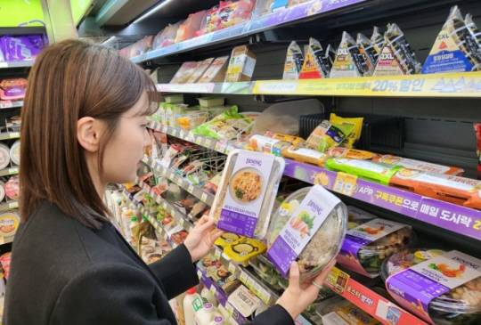 한 모델이 CU의 간편식 신규 브랜드 ‘다이닝 테이블’을 살펴보고 있다. BGF리테일 제공