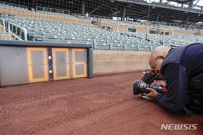 [스코츠데일=AP/뉴시스] 14일(현지시간) 미 애리조나주 스코츠데일의 솔트 리버 필드에서 한 기자가 올해 바뀌는 미 프로야구 메이저리그(MLB) 규칙 중 하나인 '피치 클록'(pitch clock)을 촬영하고 있다. MLB는 이번 시즌부터 인플레이 타구를 늘리기 위한 시프트 제한, 경기 속도를 올리기 위한 피치 클록, 주자 보호를 위한 베이스 크기 확대 등 세 가지 규칙을 개정했다. 2023.02.15.