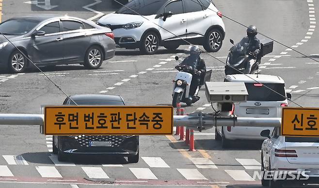 [수원=뉴시스] 김종택 기자 = 차량의 후면 번호판을 찍어 교통 법규 위반 행위를 적발해 과태료를 부과하는 방식의 단속을 하루 앞둔 31일 경기도 수원시 한 도로에 후면 무인교통 단속 카메라가 설치돼 있다. 이 단속 장비는 차량의 과속·신호 위반을 감지하고 후면 번호판을 촬영해 이륜차 위반도 단속 가능하다. 2023.03.31. jtk@newsis.com