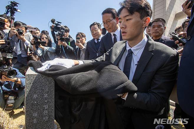 [광주=뉴시스] 김혜인 기자 = 고(故)  전두환씨의 손자인 전우원씨가 31일 오전 광주 북구 국립5 ·18민주묘지 내 김경철 열사의 묘소를 찾아 자신의 옷으로 묘비를 닦으며 넋을 위로하고 있다. 2023.03.31. hyein0342@newsis.com