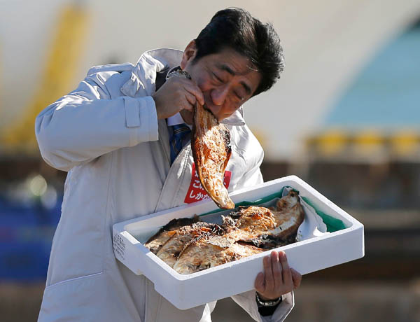일본 중의원 선거 유세가 시작된 2014년 12월 2일 아베 신조 총리가 후쿠시마현 소마의 항구에서 생선구이를 시식하고 있다. / 연합뉴스