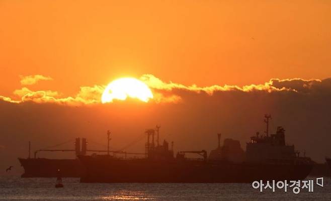 새벽, 부산항 인근에 수출 화물을 선적하기 위해 대기중인 대형 컨테이너선 위로 태양이 떠오르고 있다./부산=윤동주 기자 doso7@