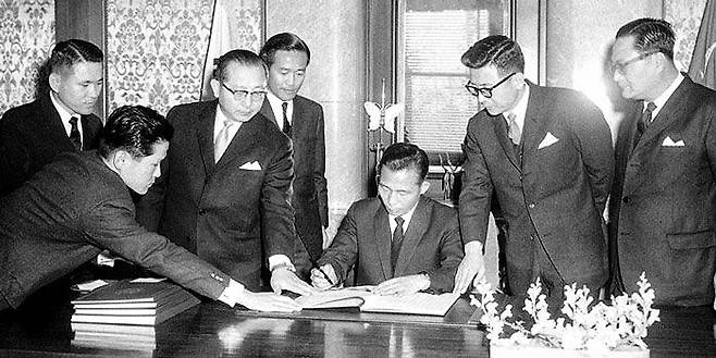 박정희(왼쪽에서 다섯째) 대통령이 1965년 12월 18일 청와대에서 한일협정 비준서에 서명하고 있다. /국가기록원