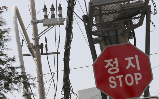 당정이 '국민 부담'을 이유로 올 2분기 전기·가스요금 인상 결정을 31일 뒤로 미뤘다. 이날 서울시내 골목에 늘어선 전깃줄.과 '정지' 도로 표시판이 나란히 눈에 띈다. 뉴시스