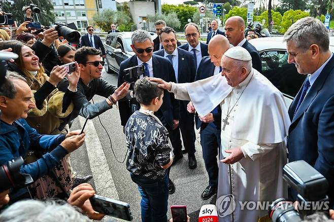 소년 축복하는 교황 (로마 AFP=연합뉴스) 프란치스코 교황이 1일(현지시간) 이탈리아 로마의 제멜리 병원에서 퇴원해 바티칸의 교황 관저로 돌아가는 중 차에서 내려 시민들과 만났다. 사진은 교황이 팔이 부러진 소년을 축복해주는 모습. 2023.4.1 photo@yna.co.kr