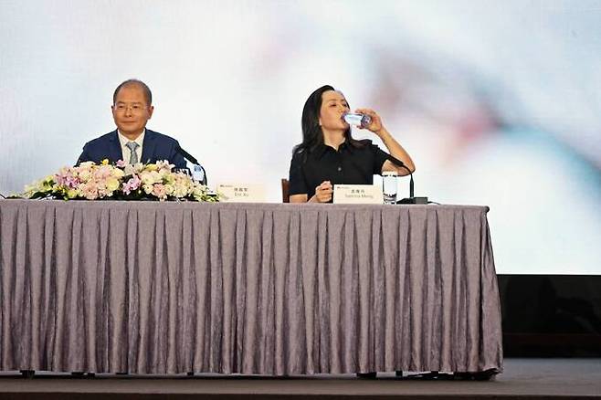 중국 광둥성 선전에서 본사에서 열린 2022년도 연례 보고서 발표 기자회견에서 멍완저우 등이 기자들의 질문에 답을 하고 있다. 뒷 배경에 엄동설한을 이겨내고 가장 먼저 꽃을 피우는 매화가 그려져 있다.