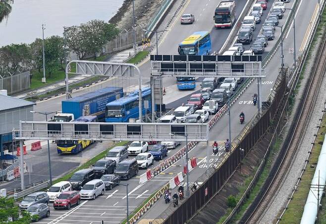 싱가포르와 말레이시아 조호르주를 오가는 차량이 지난 3월 31일 두 곳을 연결하는 다리를 메우고 있다. 싱가포르=AFP연합뉴스