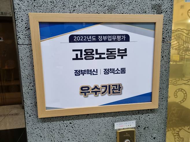 정부세종청사 11-1동 고용노동부 본부 1층에 걸린 '2022년 정부업무평가 고용노동부 정부혁신·정책소통' 우수기관 안내판. [사진=김용훈 기자]