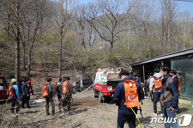 산불 진화대원들이 불길이 민가로 옮겨붙지 않게 하기 위해 소방호스로 물 뿌릴 준비를 하고 있다.(사진=금산군 제공)