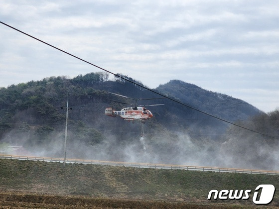 4일 오후 1시 홍성 산불의 발화지인 서부면 중리 야산 아래 저수지에서 헬기가 물을 담수하고 있다. 헬기 뒷편이 홍성 산불 발원지다. / 뉴스1 ⓒ News1 이찬선 기자