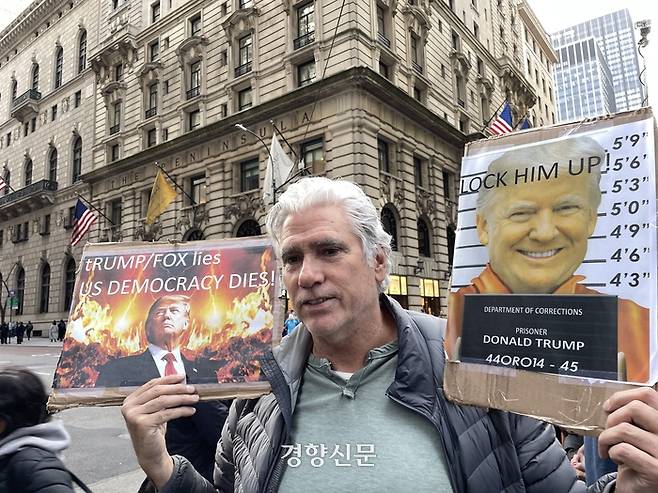 도널드 트럼프 전 대통령이 기소절차를 하루 앞두고 도착한 3일(현지시간) 뉴욕 맨해튼 트럼프타워 주변에서 만난 한 시민이 “트럼프를 감금하라”는 글자와 머그샷이 적힌 푯말을 들고 있다. 뉴욕/김유진특파원