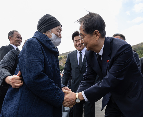 Prime Minister Han Duck-soo, right, greets a relative of a victim of the April 3 Jeju Uprising at Jeju 4.3 Peace Park on Jeju Island before attending a memorial service to commemorate the 75th anniversary of the massacre. [YONHAP]