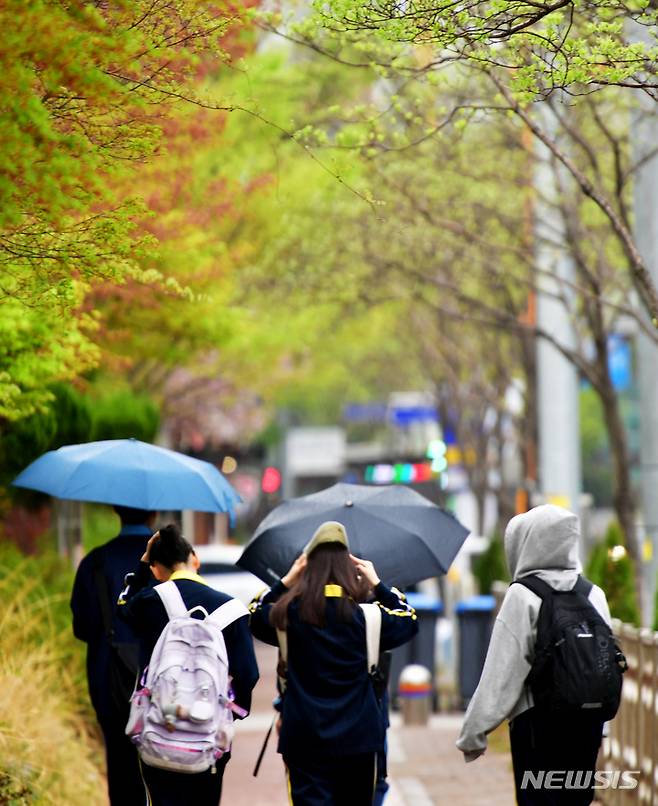 [광주=뉴시스] 이영주 기자 = 식목일을 하루 앞두고 비가 내리는 4일 오후 광주 서구 5·18기념문화센터 앞에서 학생들이 하교하고 있다. 2023.04.04. leeyj2578@newsis.com