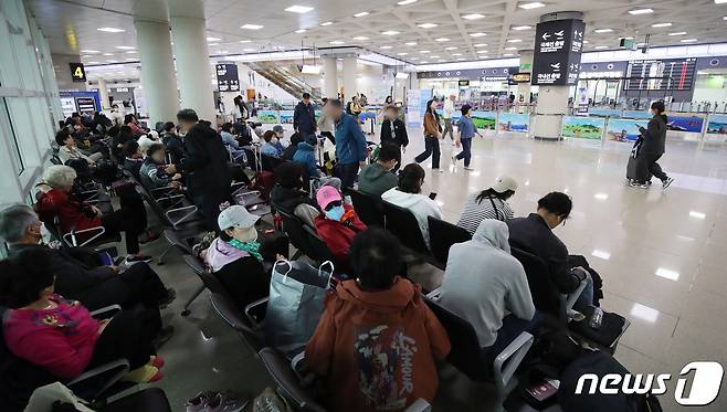 제주지역 기상악화로 항공기 결항이 이어지고 있는 5일 오전 제주국제공항 출발층에서 승객들이 대기하고 있다. 2023.4.5/뉴스1 ⓒ News1 오현지 기자