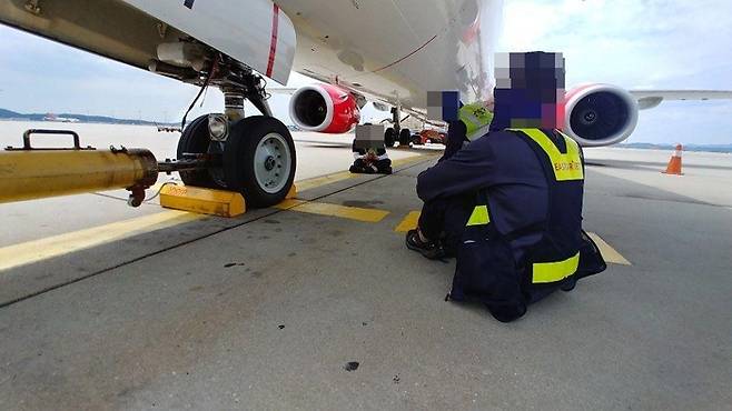 인천국제공항 지상조업 노동자가 비행기 날개 밑 그늘에서 휴식을 취하고 있다. 공공운수노조 제공