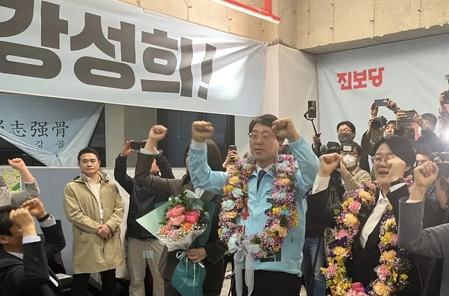 Kang Sung-hee, the Jinbo Party candidate, celebrates with his supporters after securing his victory in the by-election for the legislator of Jeonju District 2 (eul), Jeollabuk-do in his campaign office on April 6. Courtesy of Kang Sung-hee’s Election Campaign