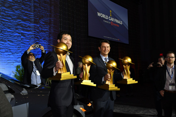 Hyundai Motor Vice President Lee Sang-yup, left, and President Jose Munoz, hold up the trophies after winning the World Car of the Year award in New York on Wednesday. [HYUNDAI MOTOR]