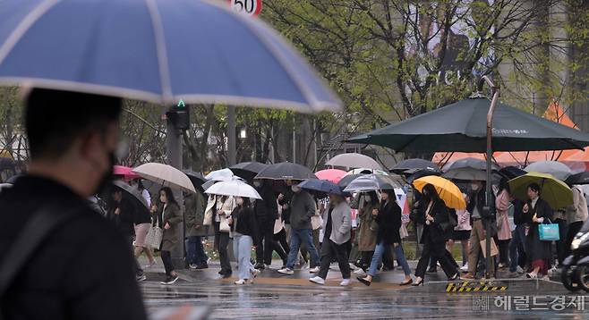 봄비가 내리는 지난 5일 오전 광화문사거리에 시민들이 우산을 들고 출근길을 서두르고 있다. [이상섭 기자]