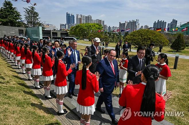 평화를 노래한 합창단 환영받는 실사단 (부산=연합뉴스) 손형주 기자 = 국제박람회기구(BIE) 실사단이 6일 오전 부산 남구 유엔기념공원을 찾아 어린이합창단 공연을 지켜 본 뒤 이동하고 있다. 2023.4.6 handbrother@yna.co.kr