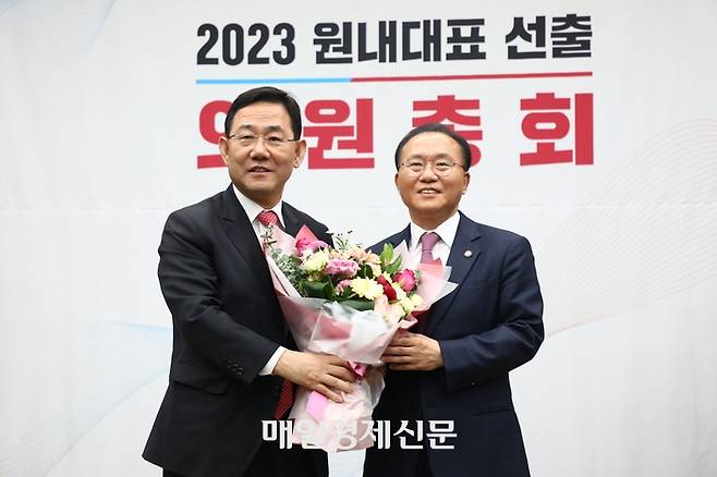 국민의힘 윤재옥 신임 원내대표(오른쪽)가 7일 서울 여의도 국회에서 열린 2023 원내대표 선출을 위한 의원총회에서 당선된 뒤 주호영 전 원내대표로부터 꽃다발을 받고 있다. 한주형기자