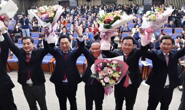 윤재옥(가운데) 국민의힘 신임 원내대표가 7일 여의도 국회에서 열린 의원총회에서 당선된 뒤 김기현(왼쪽 두 번째) 대표 등 지도부와 꽃다발을 들어 올리며 인사하고 있다. 권욱 기자