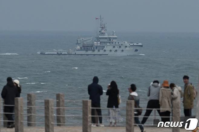 7일(현지시간) 중국 남동부 푸젠성 핑탄섬에서 관광객들이 대만 해협을 항해하는 중국 인민해방군 해군 예안선을 지켜보고 있다. 2023.4.7 ⓒ AFP=뉴스1 ⓒ News1 정윤미 기자