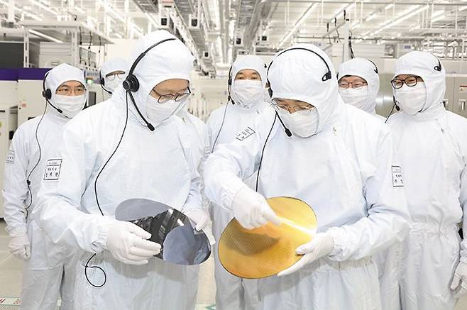 삼성 반도체 공장 찾아간 경제부총리 - 추경호(앞줄 오른쪽) 경제부총리 겸 기획재정부 장관이 7일 경기도 평택의 삼성전자 반도체 공장을 방문해 경계현(앞줄 왼쪽) 삼성전자 대표와 반도체 원재료인 웨이퍼(wafer)를 살펴보고 있다. 추 부총리는 “반도체는 한국 경제의 생명줄과 같은 산업”이라며 “초격차 확보를 위해 전폭적으로 지원하겠다”고 했다. /기획재정부