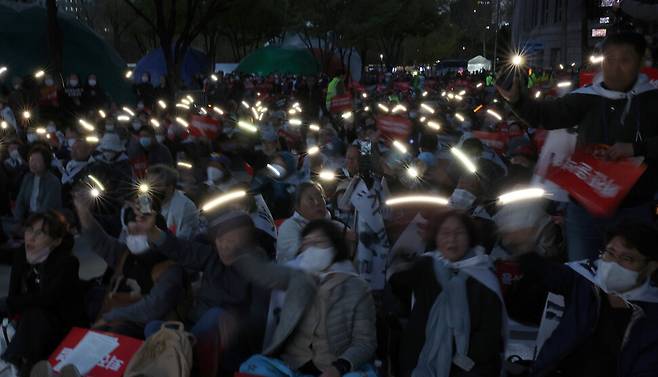 시국미사 참가자들이 핸드폰을 들고 흔들고 있다. 윤운식 선임기자