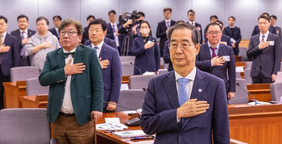 한덕수 국무총리가 10일 오후 서울 종로구 정부서울청사 별관에서 열린 2050 탄소중립 녹색성장위원회 전체 회의에서 참석해 국기에 경례하고 있다. [연합뉴스]