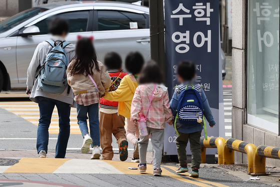 Some kindergarteners walk around their kindergarten in Seoul on Monday. [YONHAP]