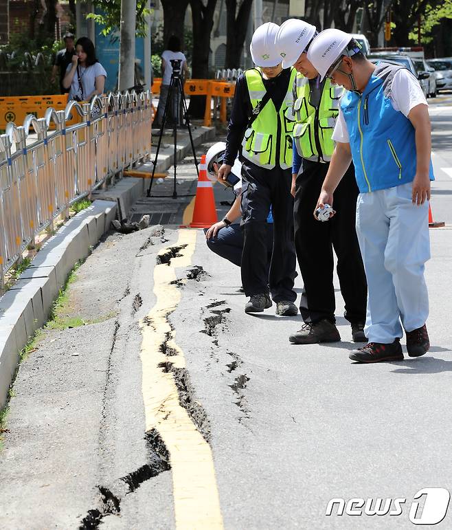 30일 오전 경기도 성남시 분당구 야탑동 야탑10교(폭 20ｍ, 길이 25ｍ)에 설치된 수도배관이 터져 균열이 생겨 건설사고조사위원회 직원들이 현장을 둘러보고 있다. 분당경찰서는 지난 29일 오후 10시 14분께 노후화된 야탑10교가 연일 이어진 폭염으로 도로가 내려앉으면서 이 사고가 발생해 교각이 왼쪽으로 8도 가량 기울고 아스팔트 도로 일부에 균열이 생겨 인근 도로를 통제중이며 정밀안전진단 결과를 보고 보수공사 여부를 결정할 것이라고 밝혔다. 2018.7.30/뉴스1 ⓒ News1 오장환 기자