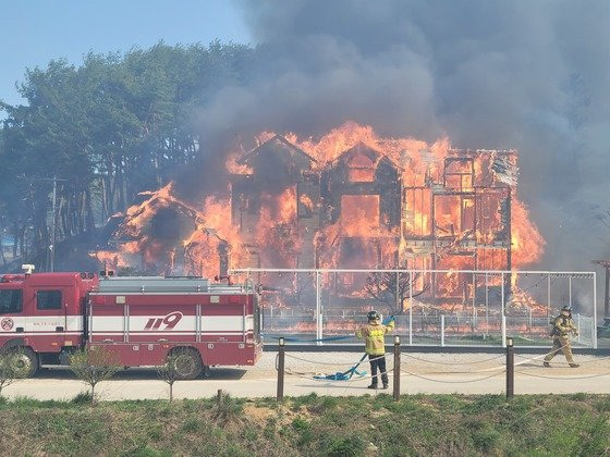 11일 강원도 강릉시 난곡동 한 야산에서 산불이 발생, 출동한 소방대원이 민가로 번진 화재를 진압하고 있다. 소방청 제공