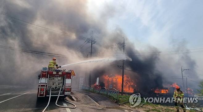 강릉서 산불…주택 화재 진화중 (강릉=연합뉴스) 유형재 기자 = 11일 오전 강원 강릉시 난곡동의 한 야산에서 불이 난 가운데 소방대원이 주택으로 옮겨붙은 불을 진화하고  2023.4.11 yoo21@yna.co.kr