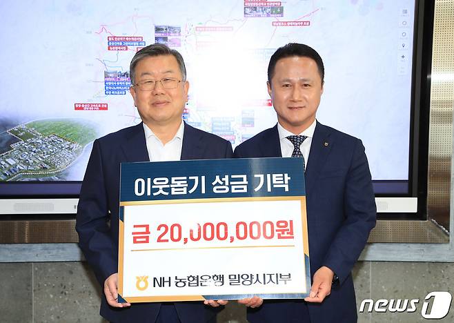 이상훈 NH농협은행 밀양시지부장이 12일 박일호 시장에 성금 2000만원을 기탁하고 있다.(밀양시 제공)