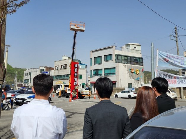 12일 오전 9시45분께 예산시장 내에 세워졌던 백종원 거리 간판이 철거되는 과정을 방문객들이 지켜보고 있다. 2023.04.12