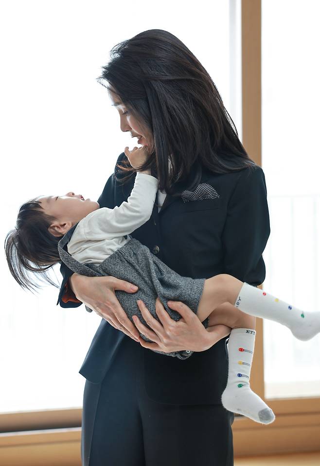 김건희 여사가 13일 2년 전 한강 투신자 수색 중 순직한 고(故) 유재국 경위의 자택을 찾아 아들 이현군을 안고 있다. /대통령실 제공