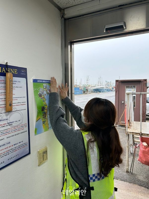 부산항만공사 직원이 감천항 내 화장실 위치를 안내하는 포스트를 붙이고 있다. ⓒ부산항만공사