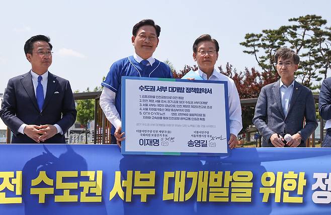 지난 2022년 5월27일 당시 송영길 더불어민주당 서울시장 후보와 이재명 인천 계양을 국회의원 후보가 경기도 김포시 고촌읍 아라 김포여객터미널 아라마린센터 앞 수변광장에서 열린 김포공항 이전 수도권 서부 대개발 정책협약식에서 기념촬영을 하고 있다. 공동취재사진