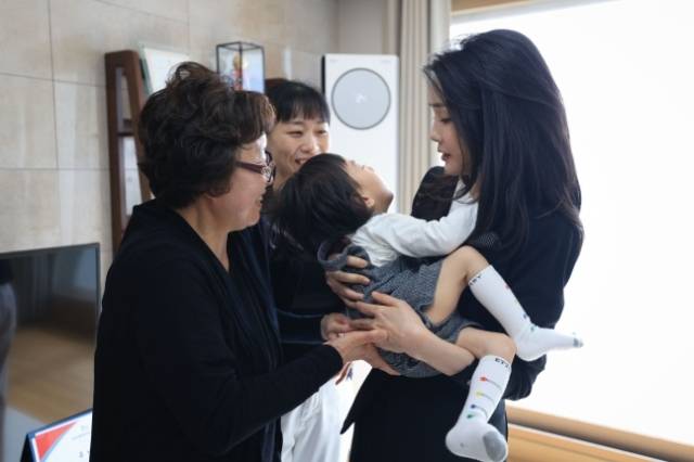 윤석열 대통령 부인 김건희 여사가 지난 13일 열린 히어로즈 패밀리 프로그램 출범식에 앞서 2020년 한강 투신 실종자 잠수 수색 중 순직한 고 유재국 경위 자택을 방문해 아들 이현 군을 안고 있다. 대통령실 제공