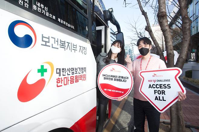 SK디스커버리와 계열사 구성원이 세계 혈우인의 날을 맞이해 혈우인을 응원하는 팻말을 들고 레드타이 챌린지를 진행하고 있다. [SK디스커버리 제공]