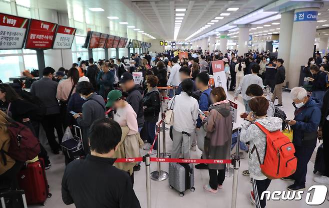 제주전역에 강풍특보가 발효된 18일 오전 제주국제공항 출발층 항공사 카운터에 대체편을 구하려는 승객들이 몰려 있다. 이날 오전 9시 기준 국내선 도착 58편, 출발 47편 등 총 105편이 결항됐다. 2023.4.18/뉴스1 ⓒ News1 오현지 기자