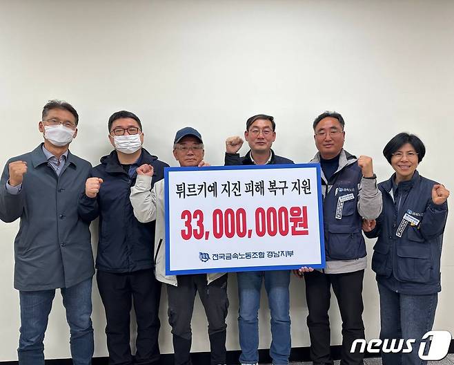 금속노조 경남지부 관계자들이 19일 튀르케예와 시리아의 지진피해 복구를 위한 성금 3300만원을 전달하는 내용의 안내판을 들고 함께 사진을 찍고 있다.(금속노조 경남지부 제공)